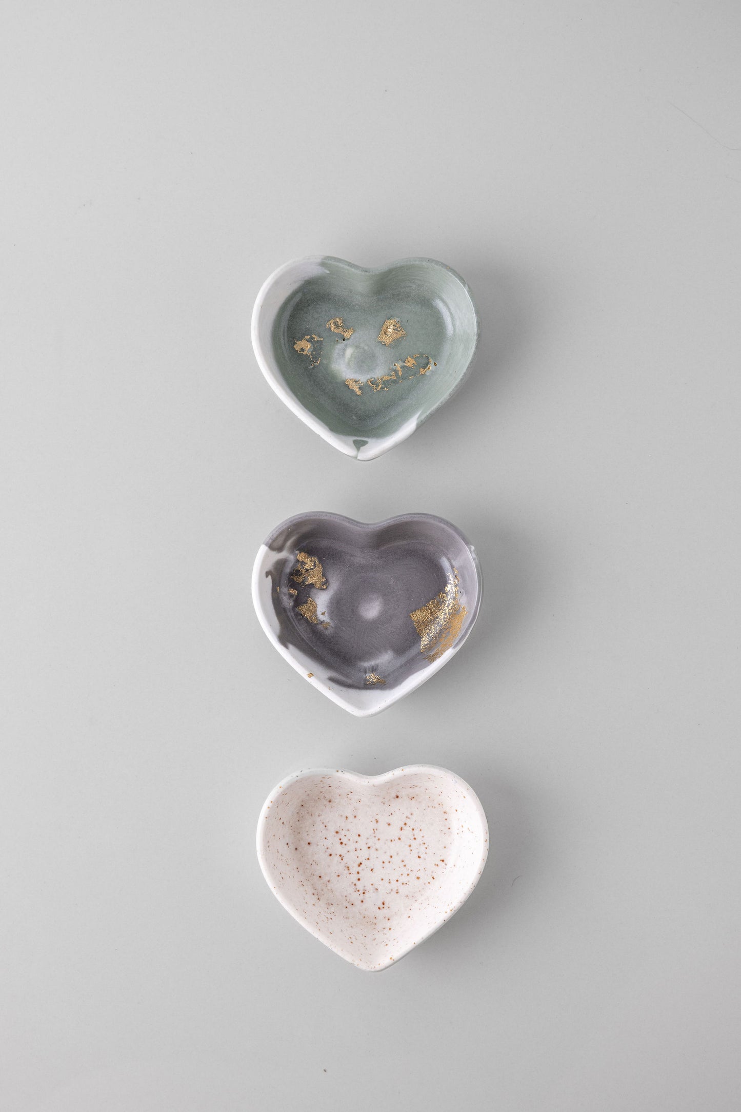 Three heart-shaped jesmonite dishes on a light gray background