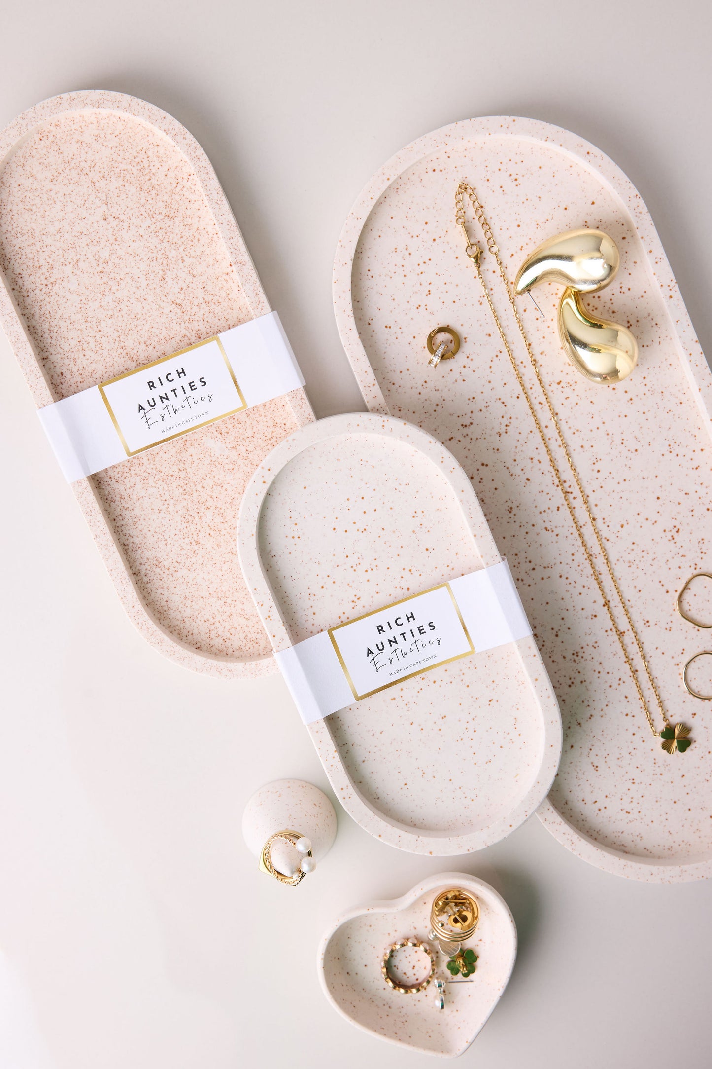 Rich Aunties Esthetics trinket Trays oatmeal design. Jesmonite trinket trays in creamy beige with fine dark brown spots holding jewelry.