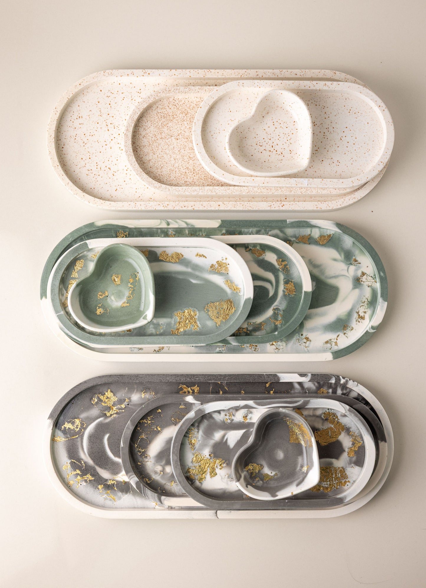 Set of marble-patterned trays with gold accents on a beige background