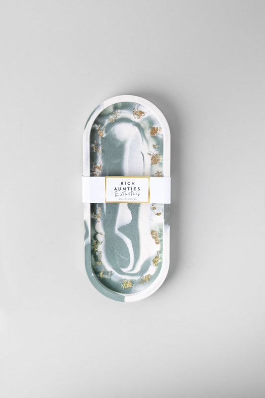 Rich Aunties Esthetics handcrafted green marble Jesmonite trinket tray with metallic gold leaf flakes holding luxury jewelry.