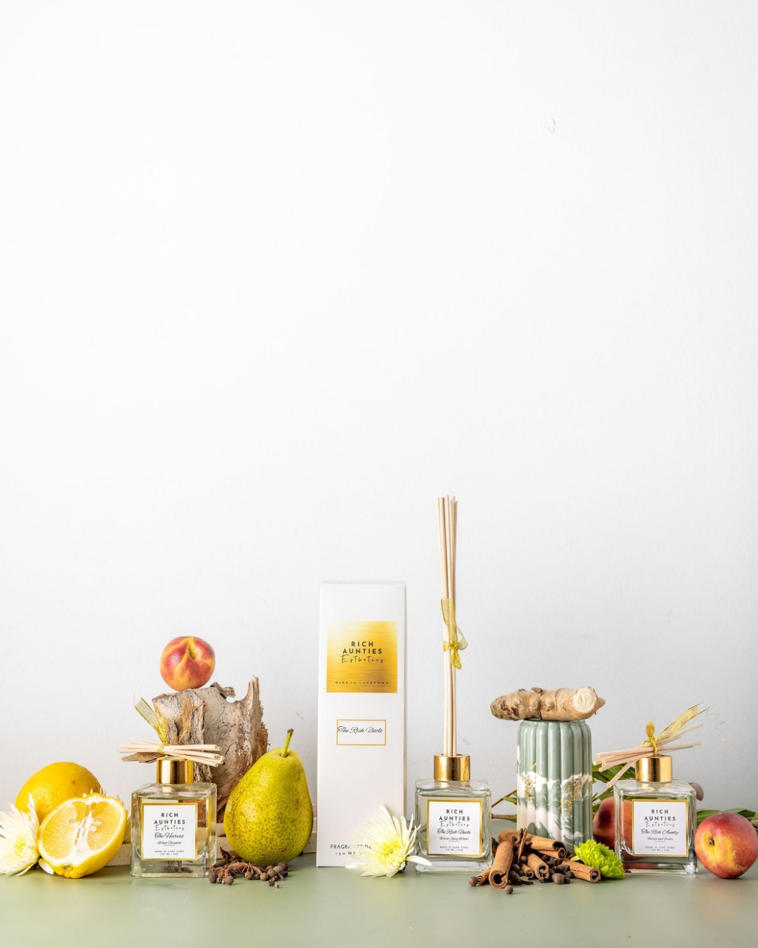 Collection of Reed Diffuser bottles and decorative cinnamon sticks_ peaches_lemons and spices