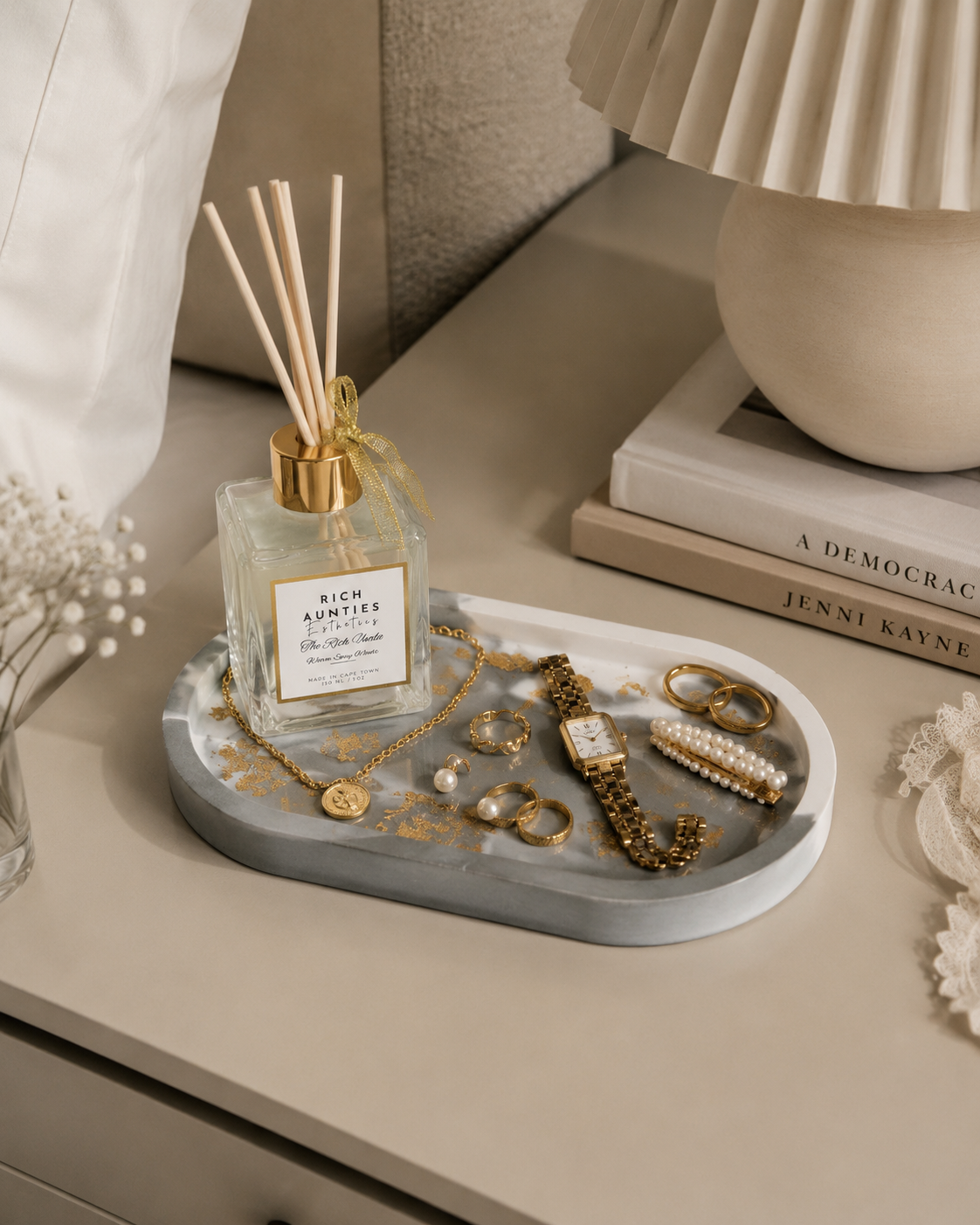 Jewelry green marble gold leaf tray with diffuser bottle, jewelry, and a lamp in the background